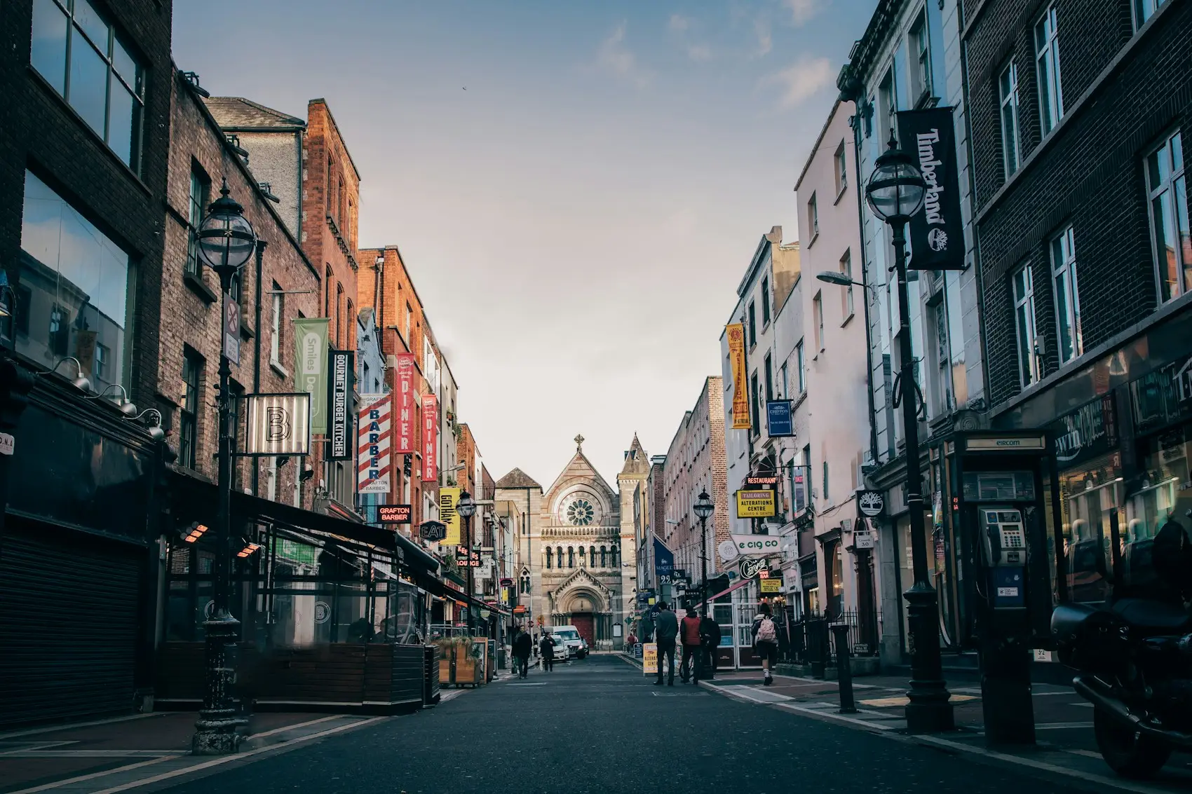 Passants dans une rue commerçante de Dublin menant à une église