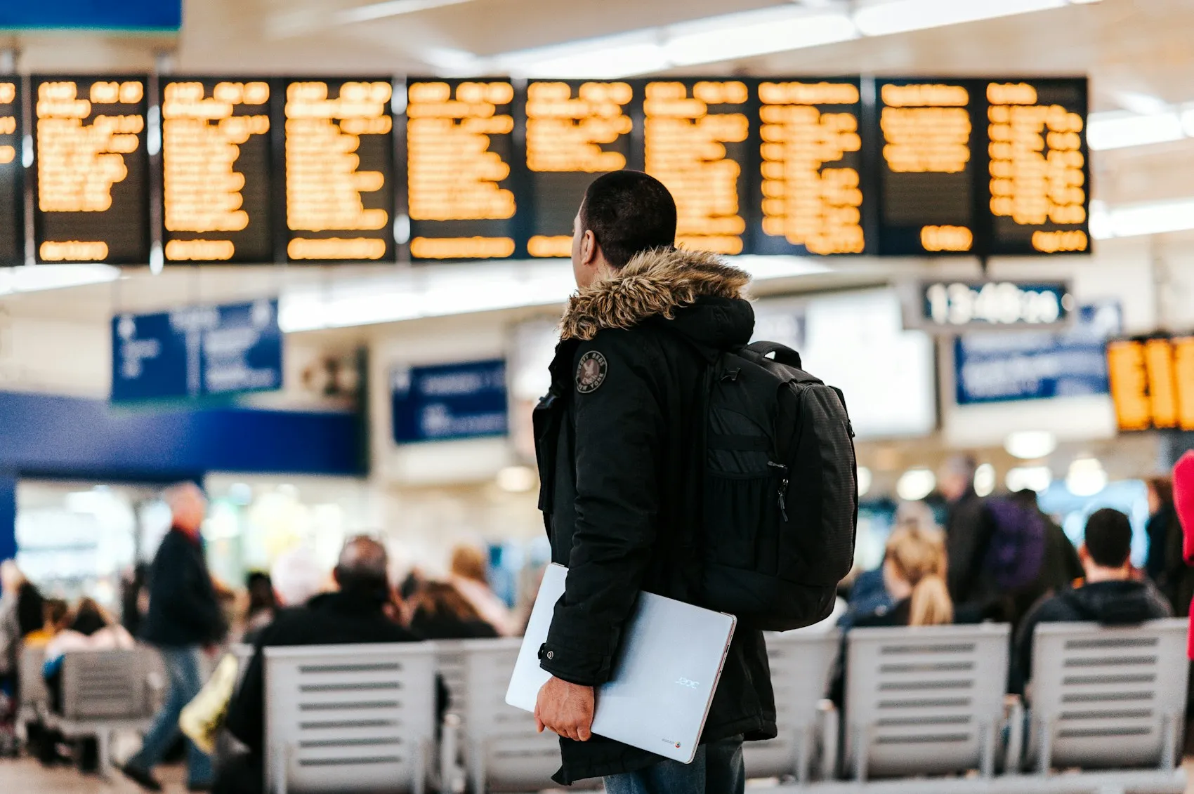 Expatrié consultant le tableau des départs dans un aéroport international